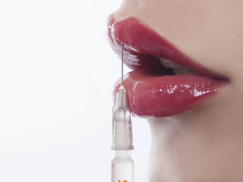 Woman with syringe on her lip Hollywood Botox