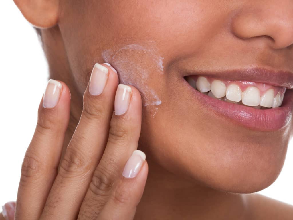 Young woman applying scar cream