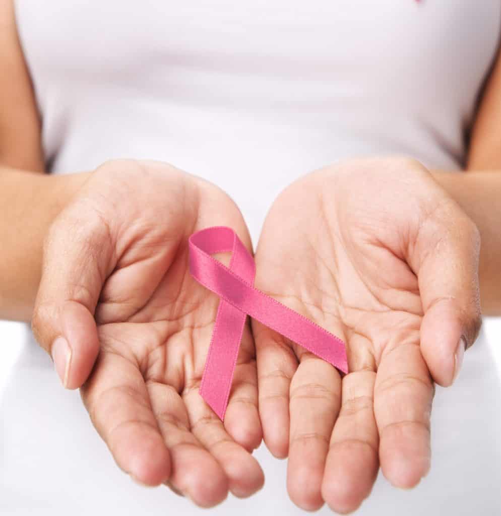 Woman showing pink ribbon to support breast cancer cause