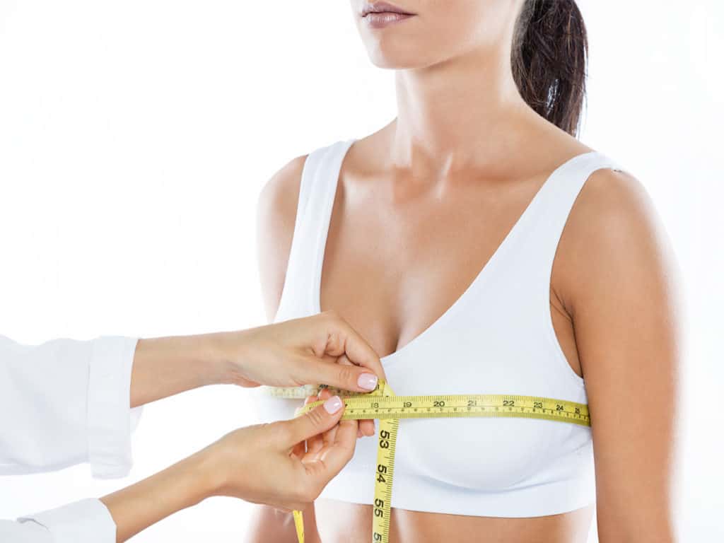 Woman measuring her breasts breast reduction